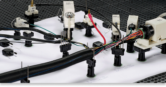 An assortment of wires and wire harnesses displayed on a table, highlighting their various colors and configurations