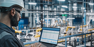 A factory engineer using his laptop computer. 