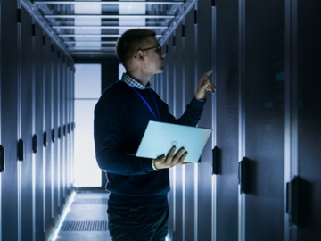 A data center operator reviews the power inside a cabinet