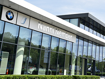 Exterior view of a car dealership with a BMW logo and the dealer name, Nanni Nember