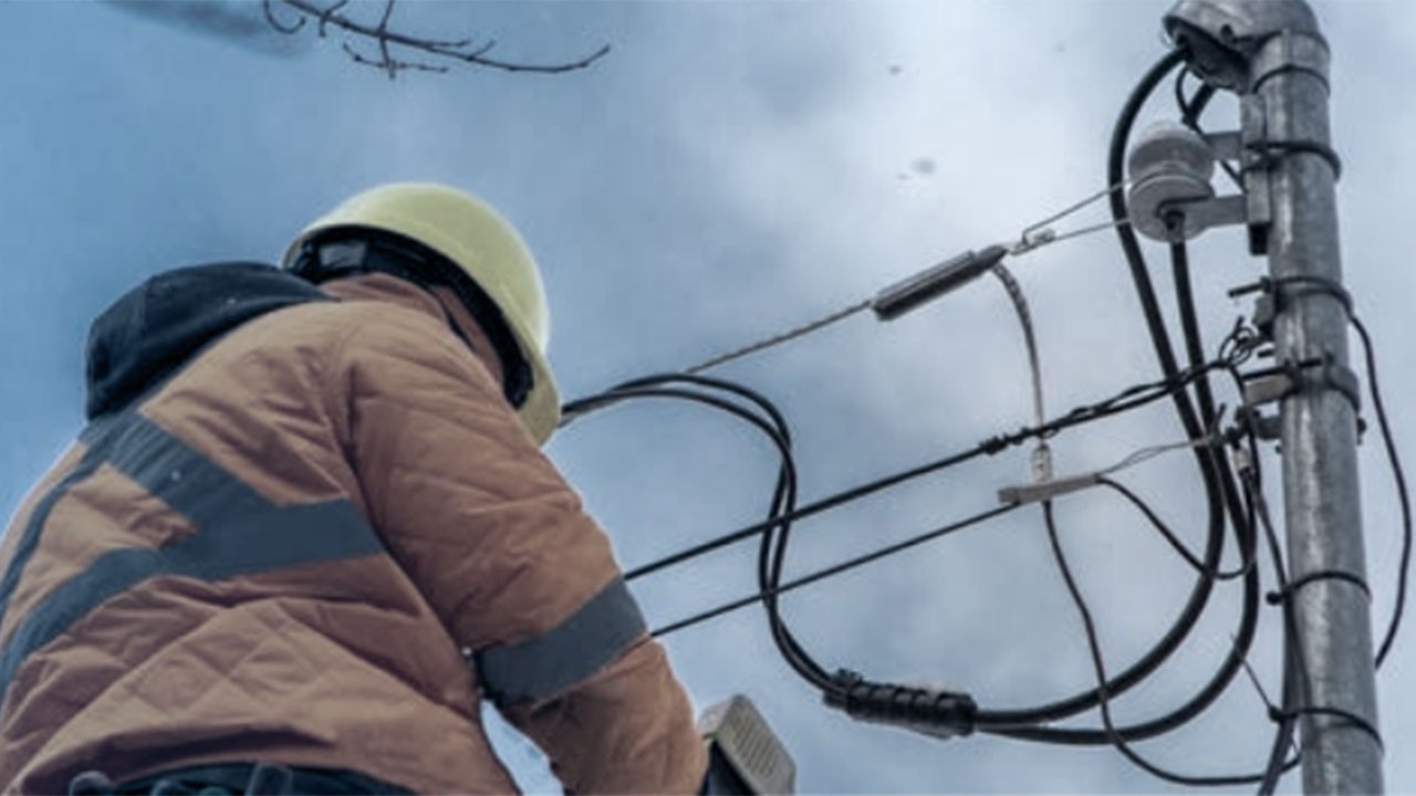 A technician on a ladder enhancing fiber optics cables